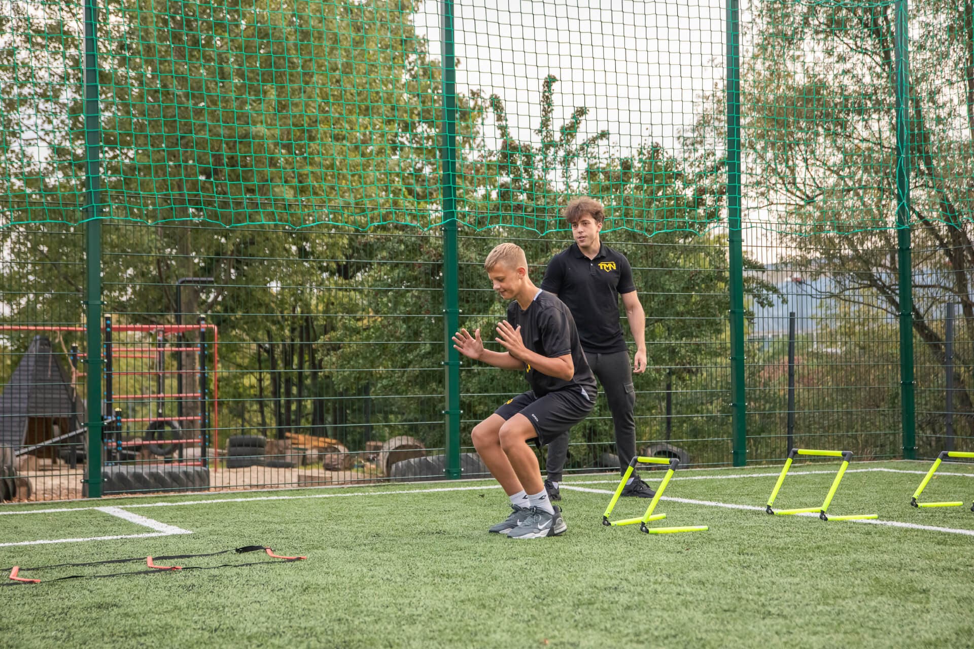 Trening siły i mocy — młody sportowiec podczas pracy plyometrycznej z trenerem TMN